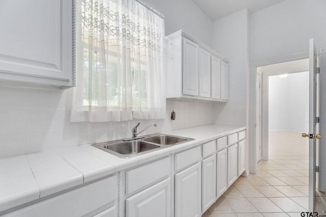 18737 Oakbrook Rd, Tyler, TX 75703 - kitchen featuring white cabinetry, tile countertops, backsplash, and light tile patterned floors