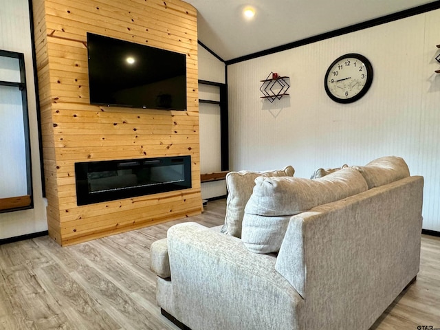 living room with hardwood / wood-style floors, vaulted ceiling, and ornamental molding