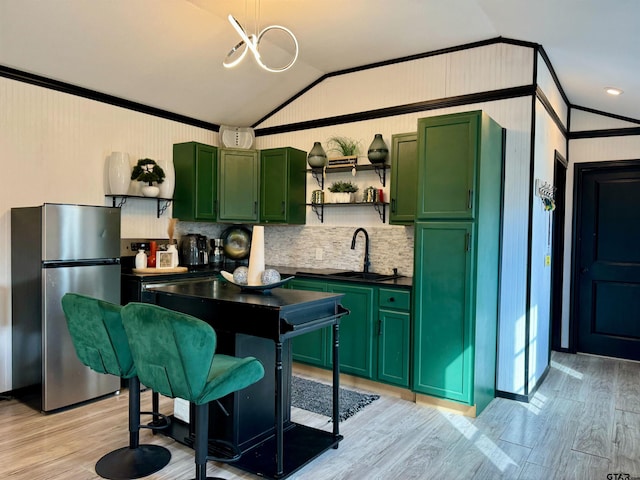 kitchen featuring light hardwood / wood-style flooring, a breakfast bar area, vaulted ceiling, and stainless steel refrigerator