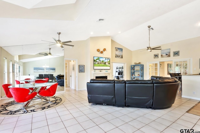 living room featuring ceiling fan, light tile patterned floors, and lofted ceiling