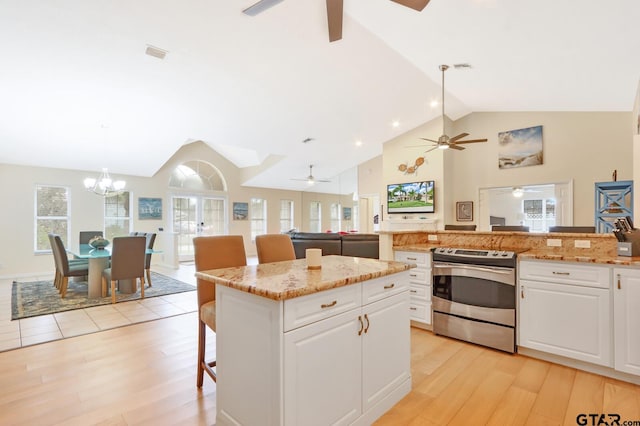 kitchen with white cabinetry, stainless steel electric range oven, hanging light fixtures, and a kitchen island