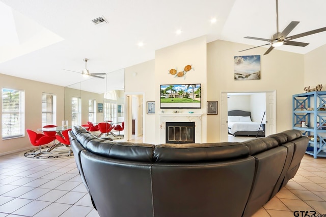 tiled living room featuring ceiling fan and vaulted ceiling