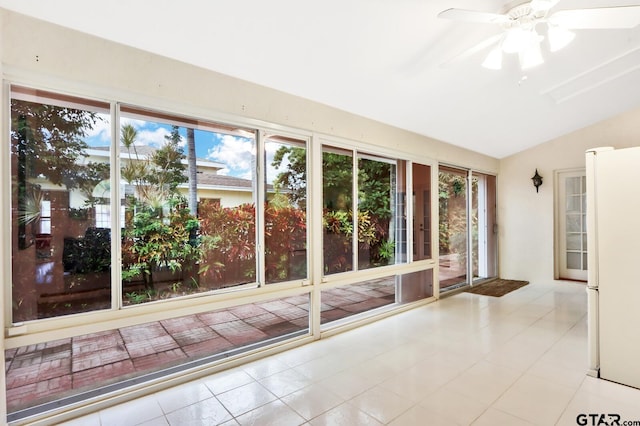 unfurnished sunroom with ceiling fan, a wealth of natural light, and vaulted ceiling