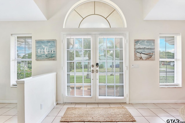 doorway with french doors, light tile patterned floors, and a healthy amount of sunlight