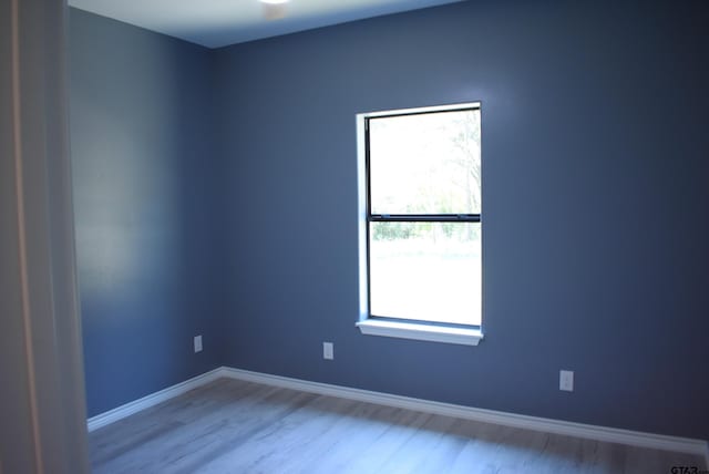 empty room featuring light wood-type flooring and a healthy amount of sunlight