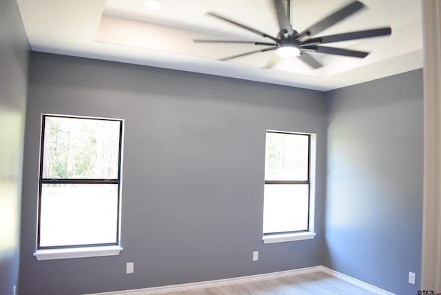 spare room with ceiling fan, light hardwood / wood-style floors, and a wealth of natural light