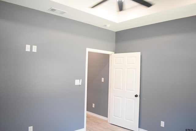 empty room with ceiling fan and light hardwood / wood-style flooring