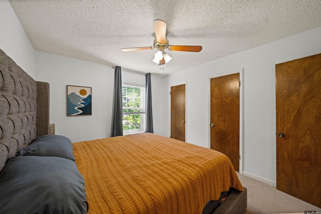 8312 Oxford Dr, Tyler, TX 75703 - bedroom featuring carpet flooring, a ceiling fan, multiple closets, and a textured ceiling