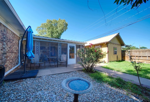 8312 Oxford Dr, Tyler, TX 75703 - back of house with a sunroom, a patio, and an outbuilding