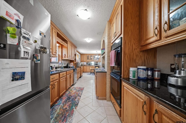 8312 Oxford Dr, Tyler, TX 75703 - kitchen featuring appliances with stainless steel finishes, a textured ceiling, light tile patterned floors, brown cabinets, and backsplash