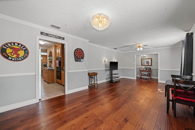 8312 Oxford Dr, Tyler, TX 75703 - living area with a textured ceiling, wood-type flooring, ceiling fan, a chandelier, and ornamental molding