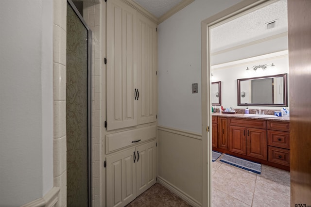 8312 Oxford Dr, Tyler, TX 75703 - bathroom featuring vanity, a stall shower, ornamental molding, a textured ceiling, and a wainscoted wall