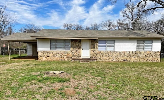single story home featuring a shingled roof, a front lawn, fence, and stone siding