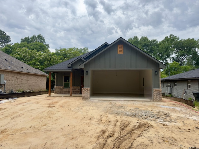 2514 N Glass, Tyler, TX 75702 - view of front facade featuring brick siding, board and batten siding, a garage, and driveway