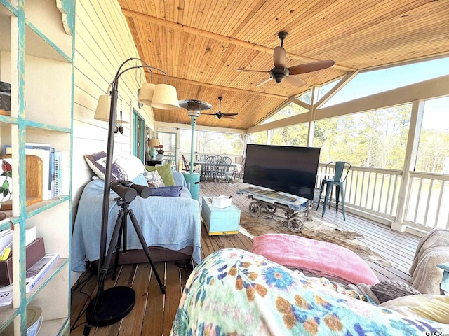 sunroom / solarium with vaulted ceiling, wooden ceiling, and ceiling fan