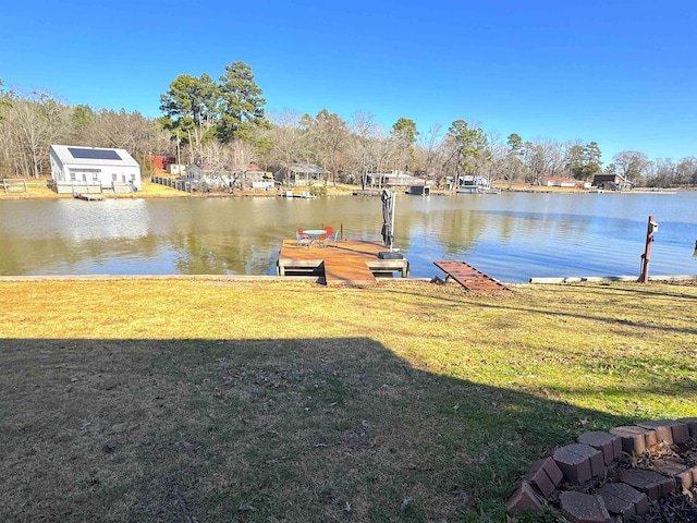 view of dock with a water view and a yard