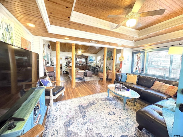 living room with wood ceiling, wood-type flooring, a raised ceiling, ceiling fan, and decorative columns