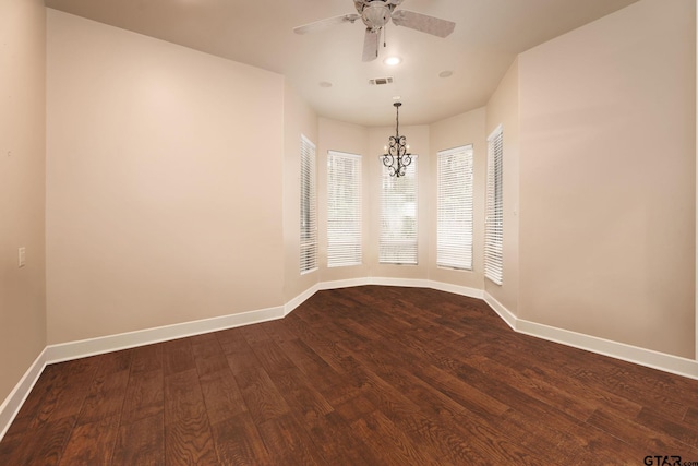 spare room with ceiling fan with notable chandelier and dark hardwood / wood-style floors