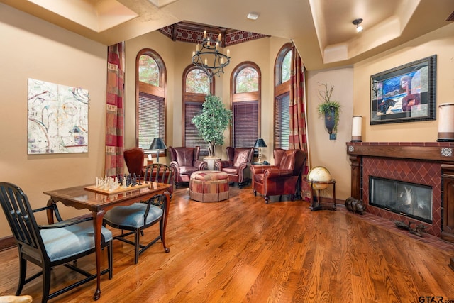 interior space with a tile fireplace, light hardwood / wood-style flooring, and a chandelier