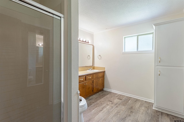 405 Brookview Ln, Palestine, TX 75803 - bathroom featuring wood finished floors, vanity, crown molding, a shower stall, and a textured ceiling