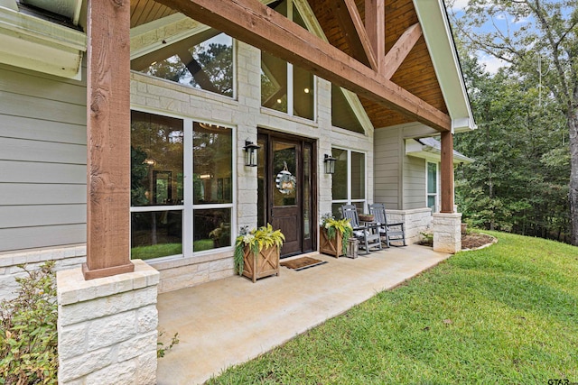 view of exterior entry featuring a lawn