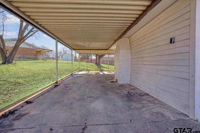 view of patio / terrace featuring an attached carport and fence