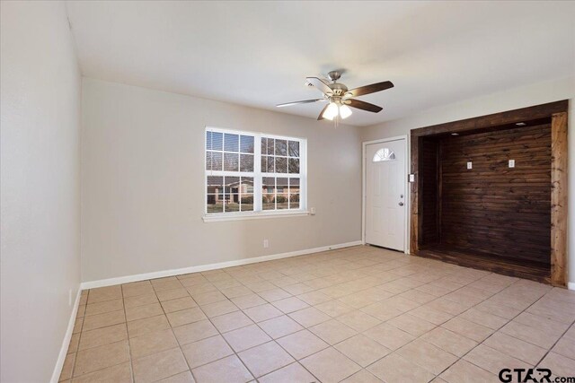 entryway with light tile patterned floors, ceiling fan, and baseboards