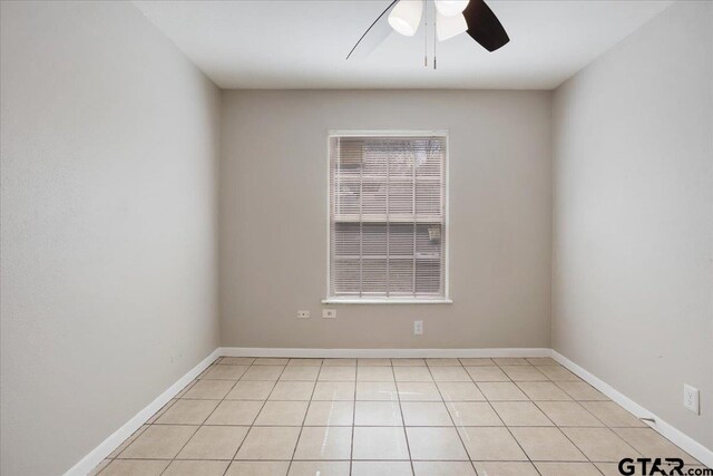 unfurnished room with light tile patterned floors, a ceiling fan, and baseboards