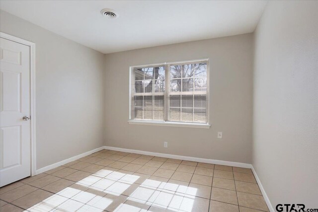 unfurnished room featuring light tile patterned floors, visible vents, and baseboards