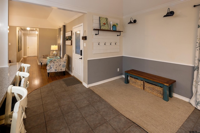 hallway featuring dark tile patterned floors, baseboards, and ornamental molding