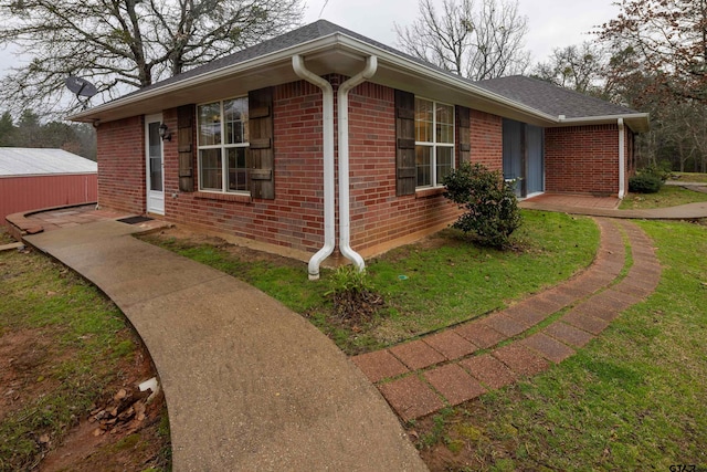 view of front of home with a front yard and brick siding