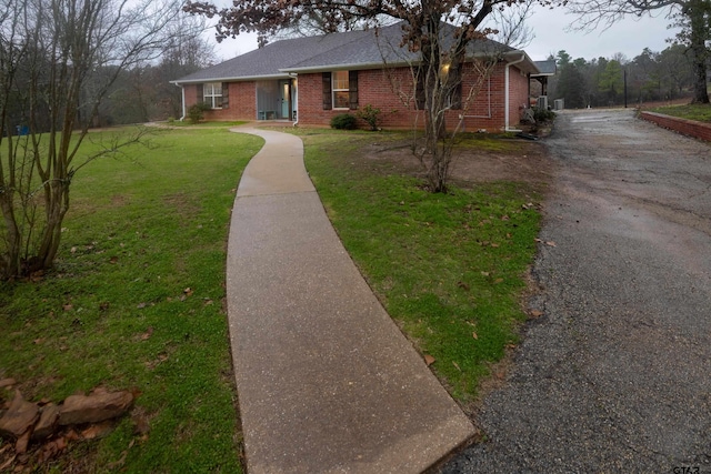 view of front of property featuring a front lawn and brick siding