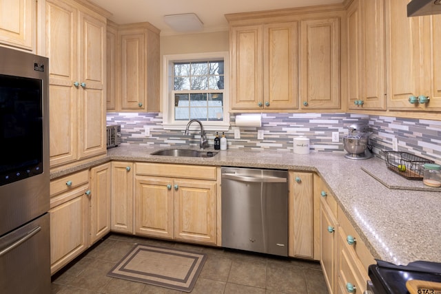 kitchen featuring decorative backsplash, light brown cabinets, a sink, dark tile patterned flooring, and dishwasher