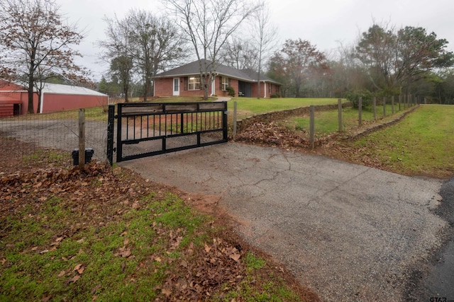 view of gate with fence and a yard