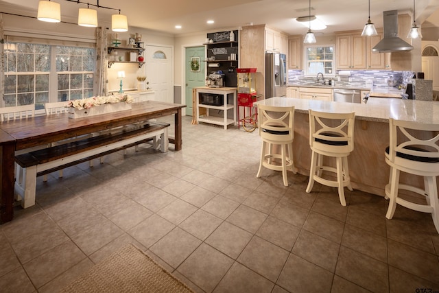 kitchen with stainless steel appliances, a sink, decorative backsplash, island exhaust hood, and pendant lighting