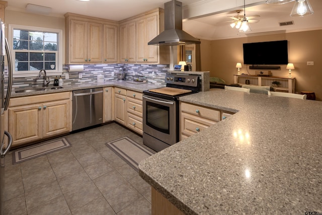 kitchen featuring light brown cabinets, stainless steel appliances, a sink, exhaust hood, and open floor plan