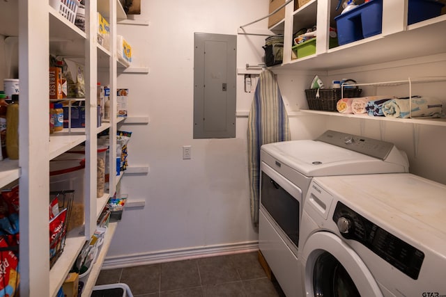 washroom with laundry area, electric panel, baseboards, dark tile patterned floors, and separate washer and dryer