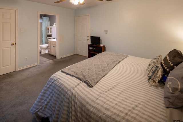 bedroom with connected bathroom, dark carpet, baseboards, and ceiling fan