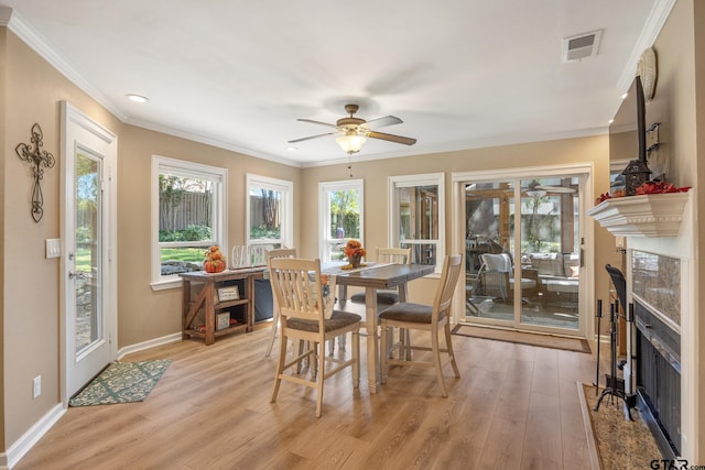 dining area with ceiling fan, crown molding, and light hardwood / wood-style flooring