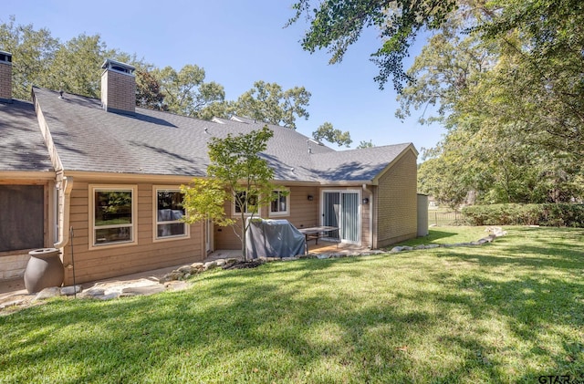 rear view of house featuring a patio and a yard