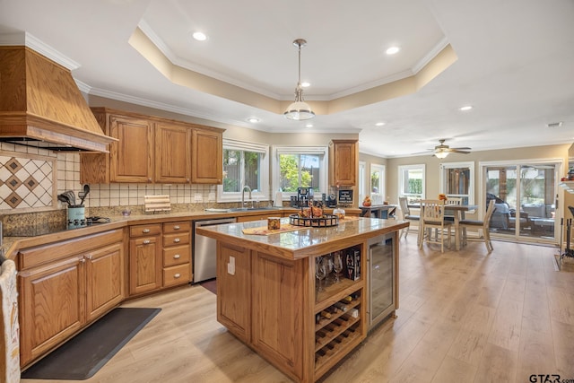 kitchen featuring a kitchen island, stainless steel dishwasher, a healthy amount of sunlight, and light hardwood / wood-style flooring