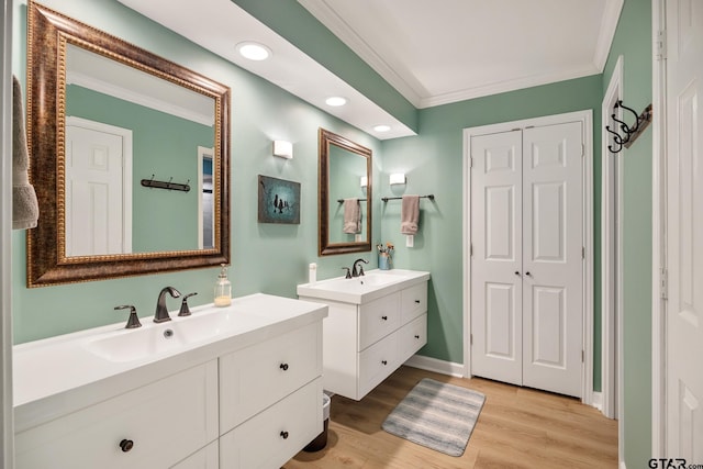 bathroom featuring vanity, hardwood / wood-style floors, and ornamental molding