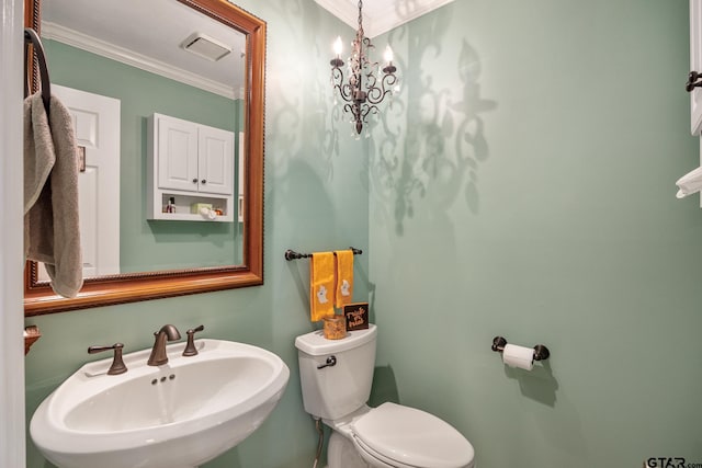 bathroom featuring ornamental molding, toilet, sink, and a chandelier