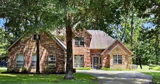 view of front of property featuring a front lawn and brick siding