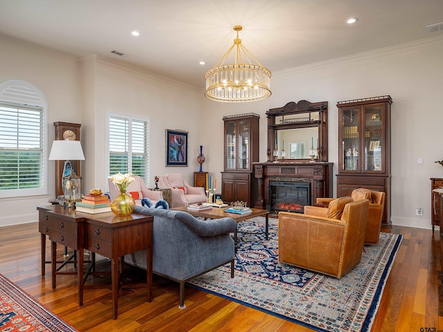 living room with crown molding, an inviting chandelier, and dark hardwood / wood-style flooring