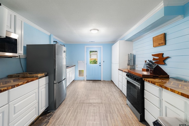 408 Morton Ave, Palacios, TX 77465 - kitchen with wood counters, appliances with stainless steel finishes, white cabinetry, ornamental molding, and light wood-type flooring