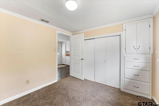 unfurnished bedroom with crown molding, a closet, and carpet