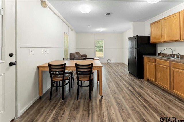 dining room with a textured ceiling, dark wood-type flooring, and sink