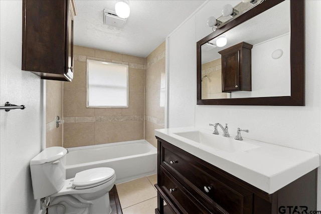 full bathroom with tile patterned floors, a textured ceiling, toilet, vanity, and tiled shower / bath