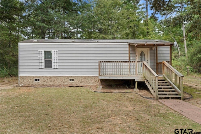 manufactured / mobile home featuring a wooden deck and a front yard